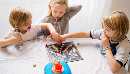 Kids at a table playing board game to reduce screen time.
