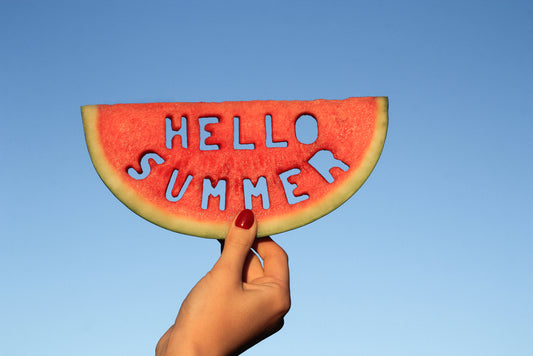 Concept for Spotify summer playlist, woman's hand holding a watermelon slice with text, Hello Summer. 