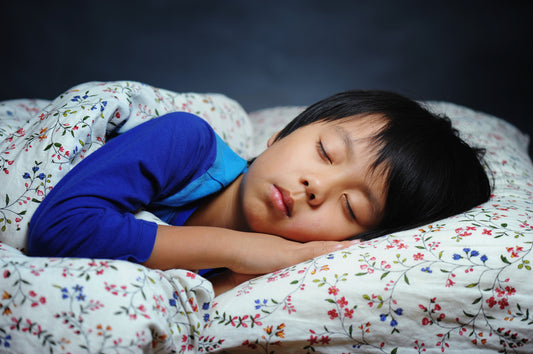 A kid sleeping peacefully whilst listening to sleep music for kids.